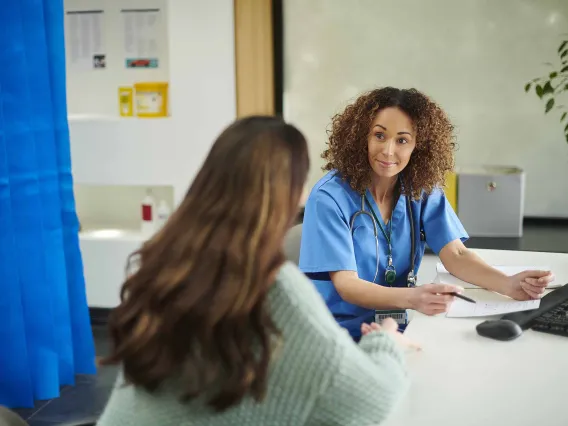 doctor smiles at patient while reviewing a medication prescription