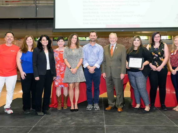 group of 10 people receiving an award