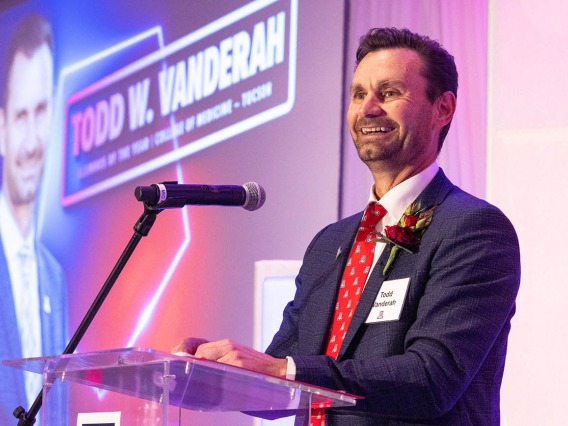 Pain and addiction researcher and professor Todd Vanderah standing smiling behind lecturn