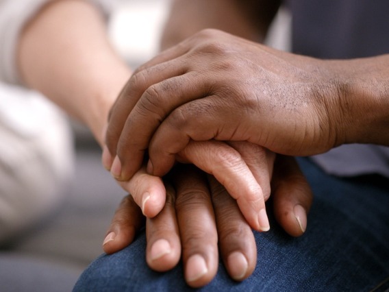 closeup of two people holding hands in show of support