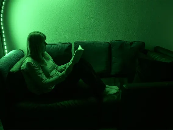 chronic pain patient reads a book while sitting under green light 