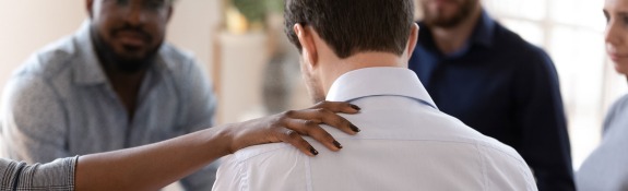 African American woman comforting male in inter-racial support group