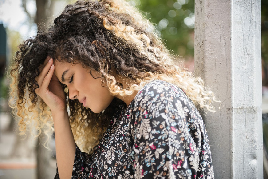 woman holding head in pain