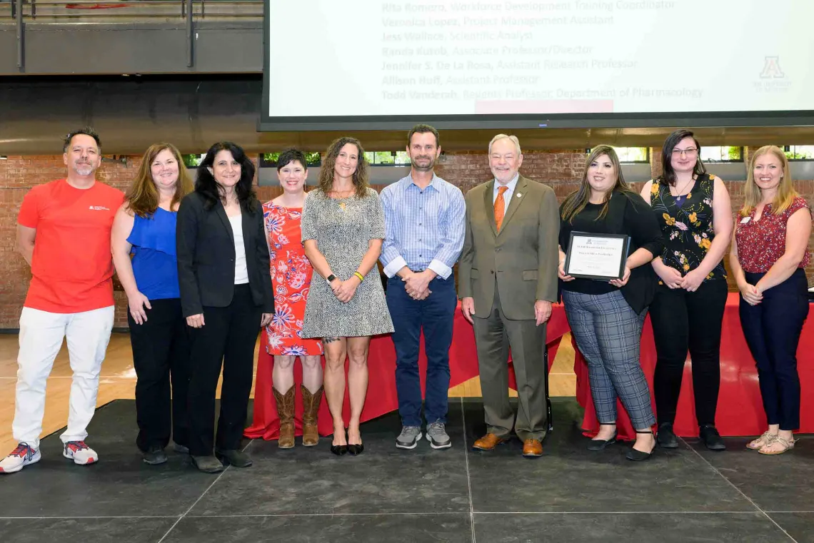 10 people lined up for a group photo after winning a team award