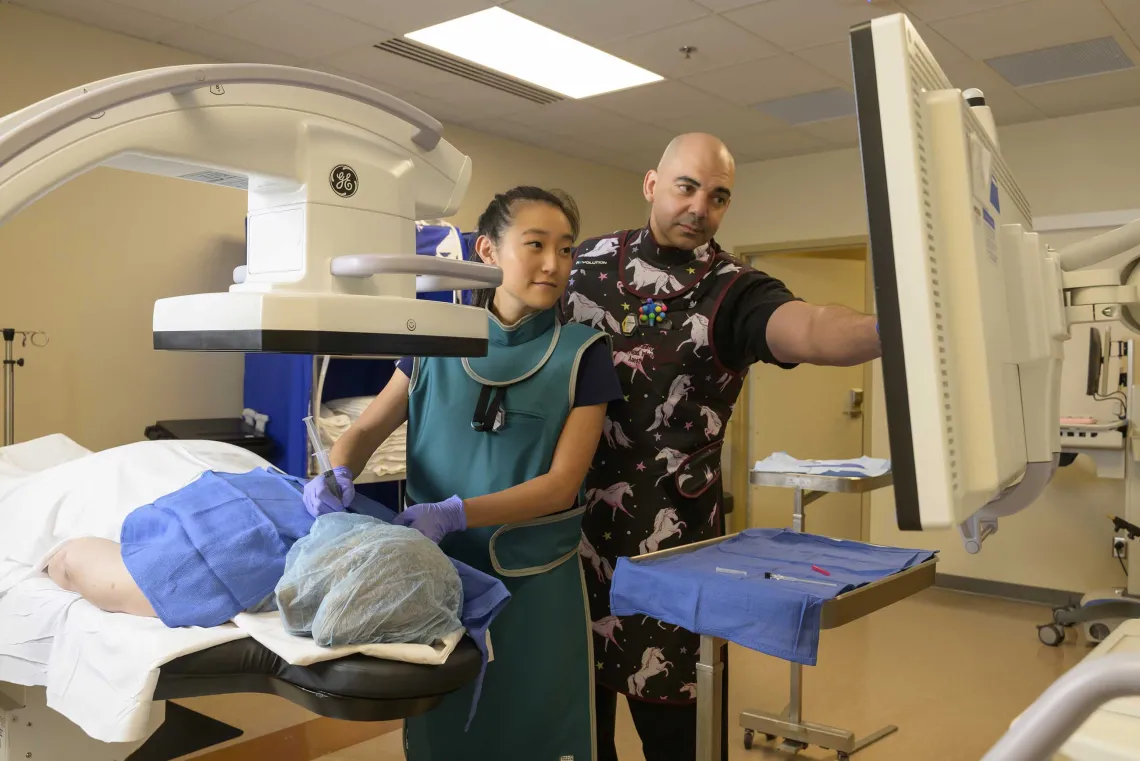 two pain management doctors perform a procedure on a patient in an outpatient room