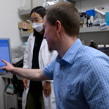 male researcher pointing at computer screen