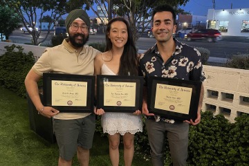 three pain management doctors post with plaques at their fellowship graduation