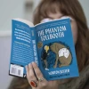 close up of book "The Phantom Tollbooth" being read by a person