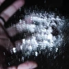 white powder on black mirror with hand in the background